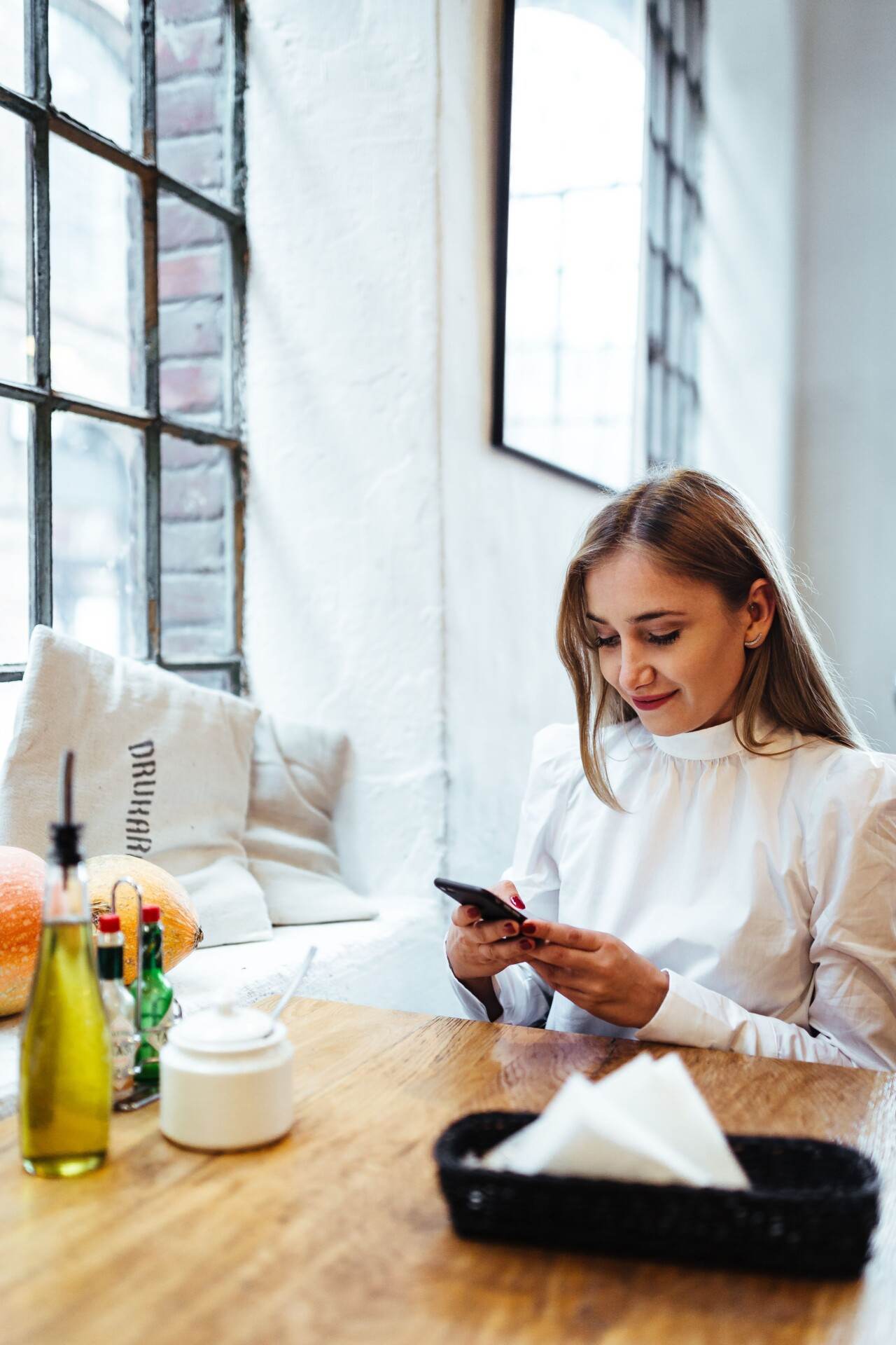 PPC for Ecommerce service - a woman looks at her phone. She is smiling at the successes of her Google Ads led by Dan Roberts Marketing an Ecommerce PPC agency